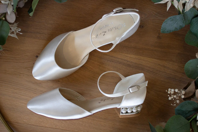 Zapatos de novia Aguamarina en color ivory con abertura lateral, tacón adornado con perlas y diseño plano, ideales para bodas y eventos elegantes.