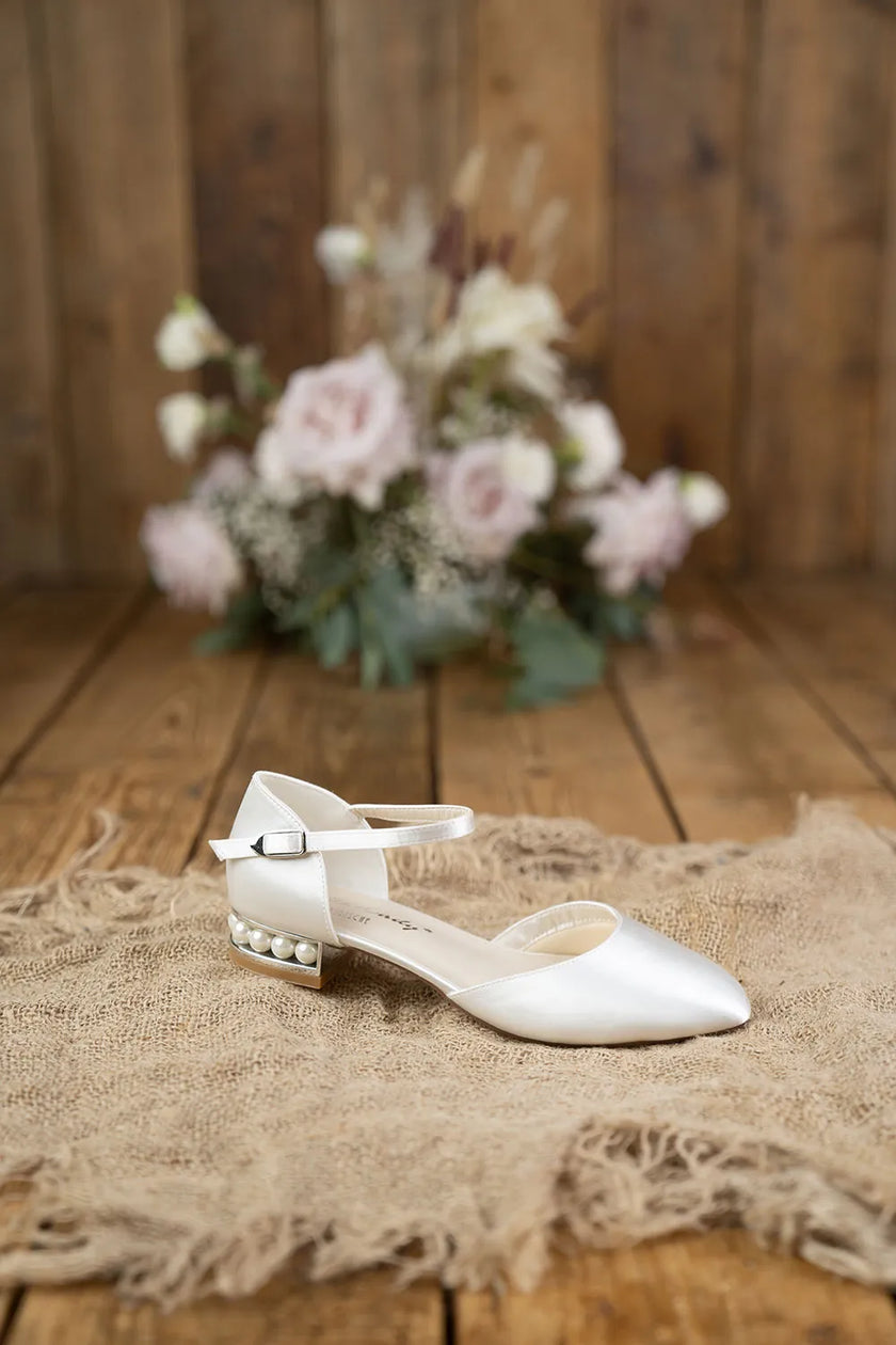 Zapatos de novia Aguamarina en color ivory con abertura lateral, tacón adornado con perlas y diseño plano, ideales para bodas y eventos elegantes.