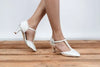 Zapatos de novia Rodonita en color ivory con detalles de perlas, tacón elegante y correa en T, perfectos para bodas y eventos especiales.